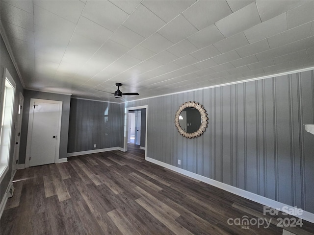 unfurnished room featuring wooden walls, dark wood-type flooring, and ceiling fan