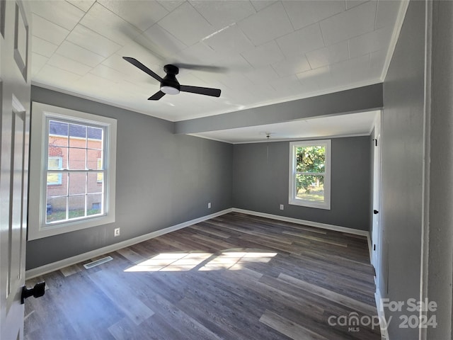 spare room with ornamental molding, dark hardwood / wood-style floors, plenty of natural light, and ceiling fan