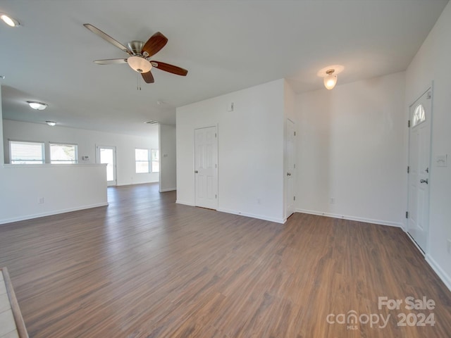 unfurnished living room with wood finished floors, ceiling fan, and baseboards