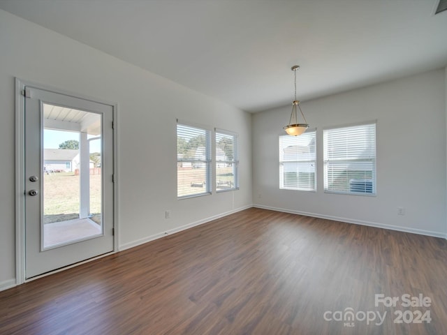 empty room with plenty of natural light and dark hardwood / wood-style floors