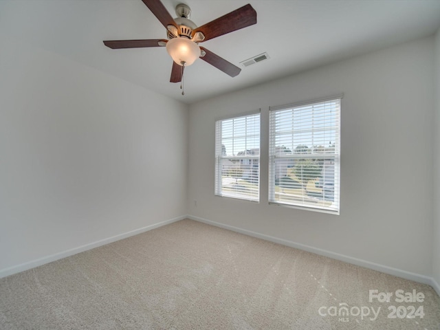 carpeted spare room with ceiling fan