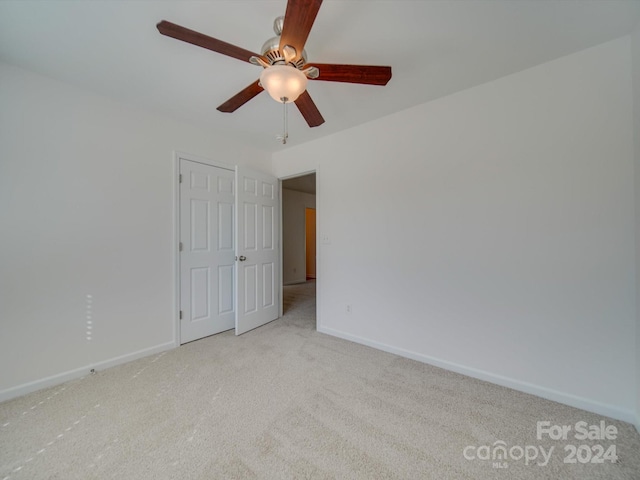 carpeted spare room featuring ceiling fan