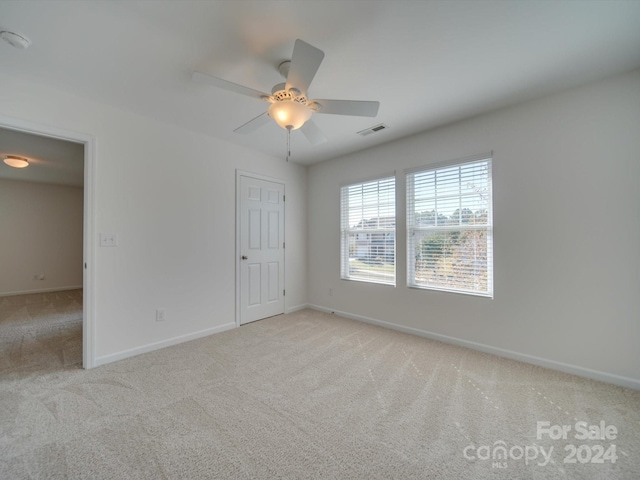 spare room with light carpet and ceiling fan