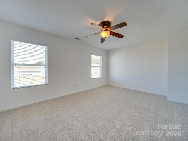 empty room featuring light colored carpet and ceiling fan