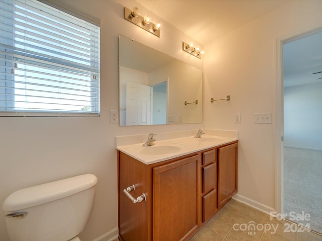 bathroom featuring vanity, a healthy amount of sunlight, toilet, and tile patterned floors