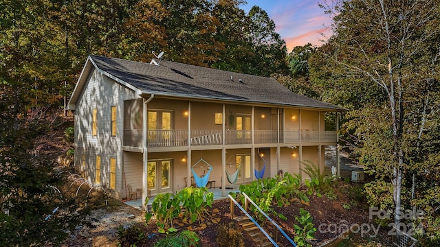 view of front of home with a patio, french doors, and a balcony