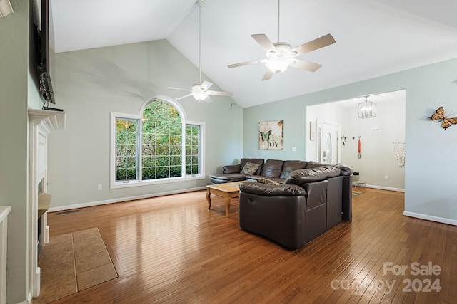 living room with hardwood / wood-style flooring, high vaulted ceiling, and ceiling fan