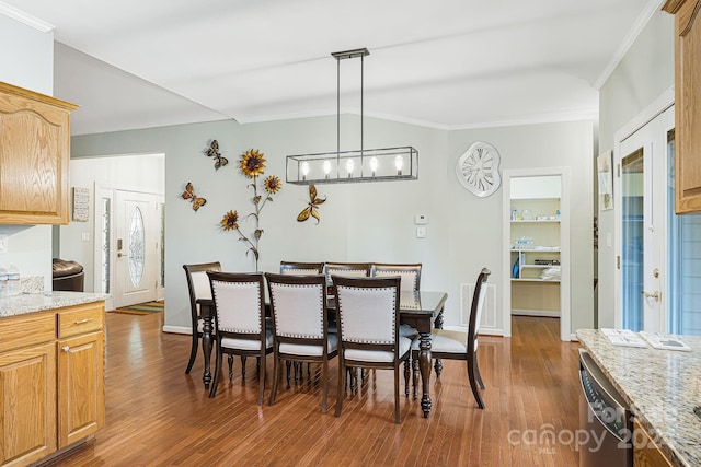 dining space with crown molding, a chandelier, and dark hardwood / wood-style floors