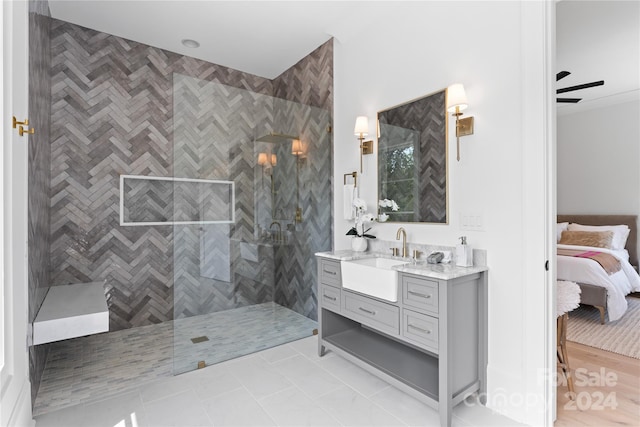 bathroom featuring vanity, tiled shower, ceiling fan, and tile patterned flooring