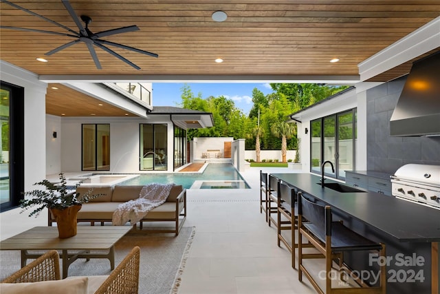 view of patio with area for grilling, an outdoor wet bar, an outdoor hangout area, ceiling fan, and a grill