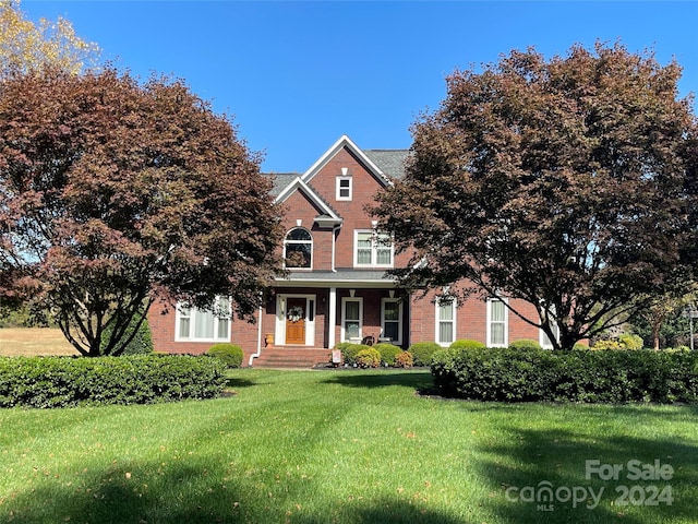 view of front of property with brick siding and a front yard