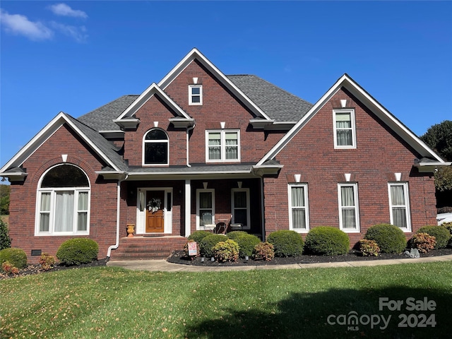 view of front of property with covered porch and a front yard