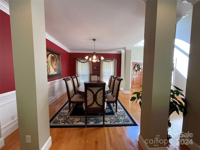 dining space with crown molding, light hardwood / wood-style flooring, and a chandelier