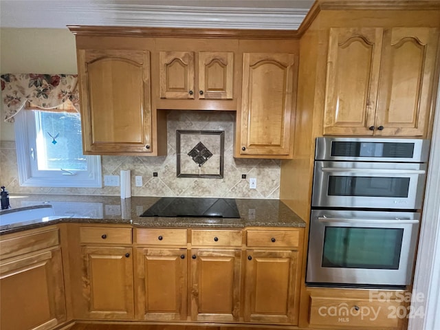 kitchen featuring stainless steel double oven, black electric cooktop, dark stone countertops, and tasteful backsplash