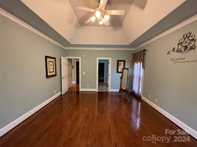 unfurnished bedroom with dark wood-type flooring, ceiling fan, ornamental molding, and a tray ceiling