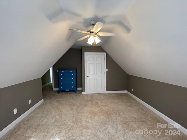 additional living space featuring vaulted ceiling, light carpet, and ceiling fan