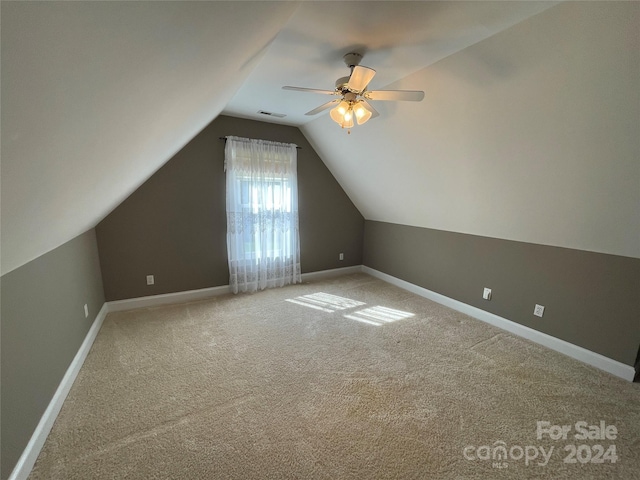 additional living space with baseboards, ceiling fan, carpet, and lofted ceiling