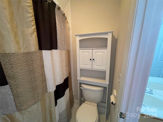 bathroom with toilet and curtained shower