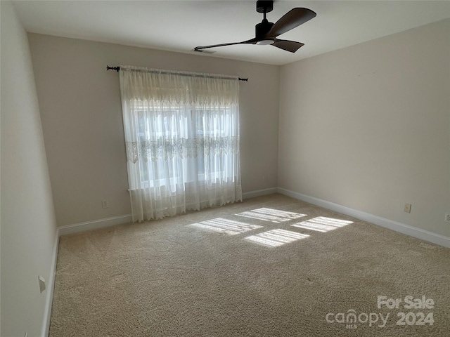 carpeted spare room with ceiling fan