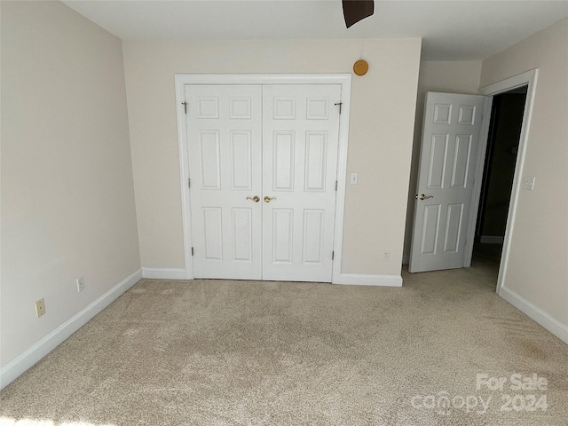 unfurnished bedroom with carpet flooring, a closet, and ceiling fan