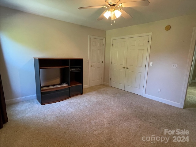 interior space with carpet flooring, ceiling fan, and baseboards
