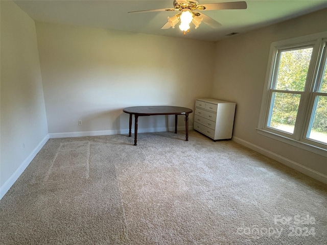 unfurnished bedroom featuring baseboards, light carpet, and a ceiling fan