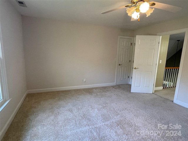 carpeted spare room with ceiling fan