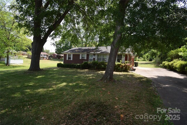ranch-style home featuring a front lawn and driveway