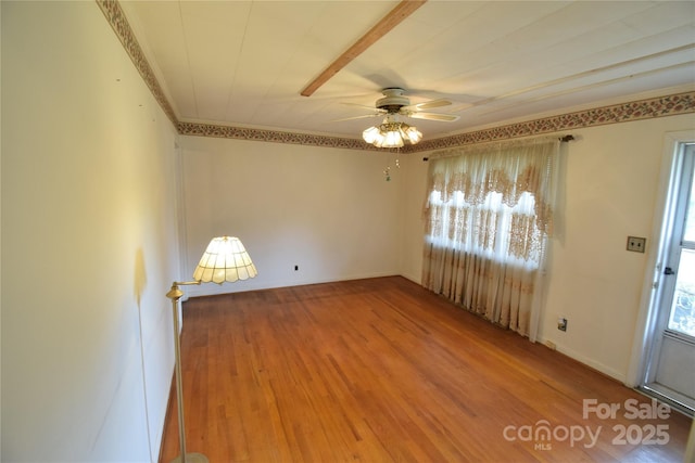 spare room with ceiling fan, ornamental molding, and wood finished floors