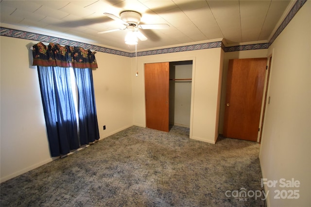 unfurnished bedroom featuring carpet flooring, crown molding, ceiling fan, and a closet