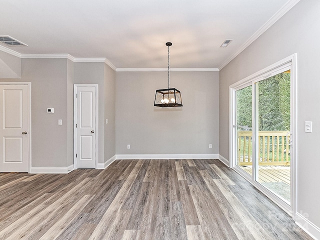 empty room with hardwood / wood-style floors, ornamental molding, and a chandelier