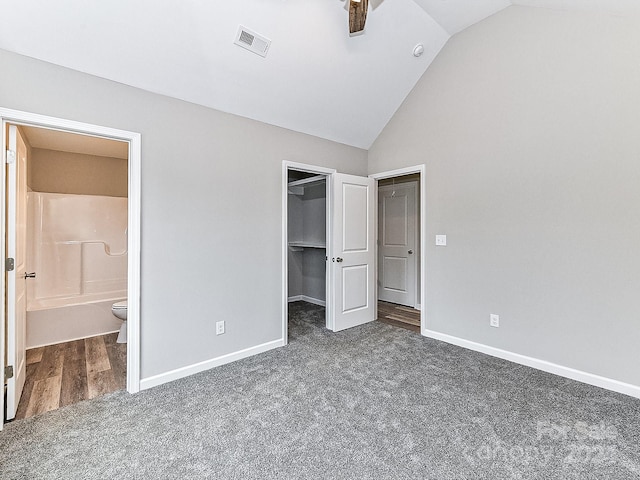 unfurnished bedroom with ensuite bathroom, vaulted ceiling, ceiling fan, a spacious closet, and a closet