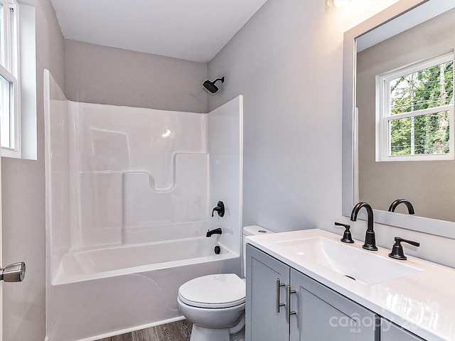 full bathroom with hardwood / wood-style flooring, vanity, toilet, and bathing tub / shower combination