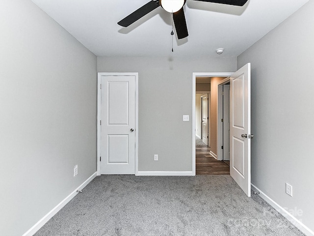 unfurnished bedroom featuring ceiling fan and carpet