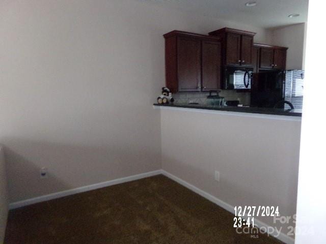 kitchen featuring kitchen peninsula and dark colored carpet