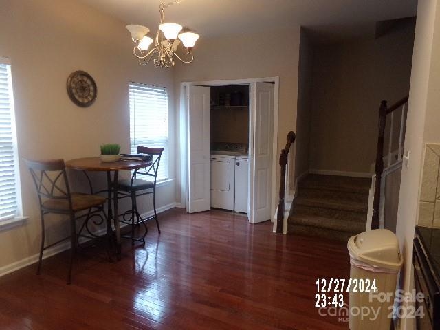 dining space with washer and dryer, dark wood-type flooring, and a notable chandelier