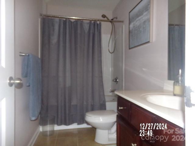 full bathroom featuring tile patterned flooring, vanity, toilet, and shower / bathtub combination with curtain