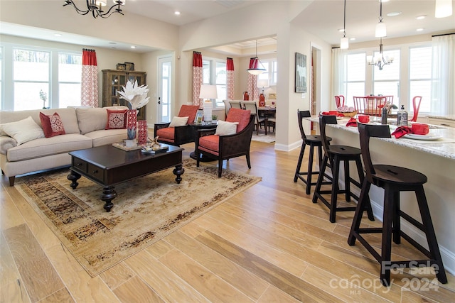 living room featuring light hardwood / wood-style flooring, an inviting chandelier, and plenty of natural light