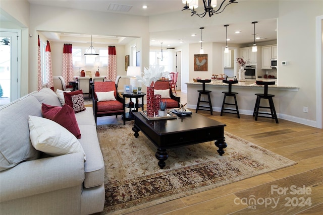 living room featuring light hardwood / wood-style floors and an inviting chandelier