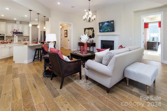 living room with a chandelier and light hardwood / wood-style flooring