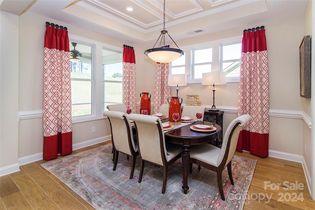 dining room with ceiling fan, coffered ceiling, ornamental molding, and light hardwood / wood-style flooring