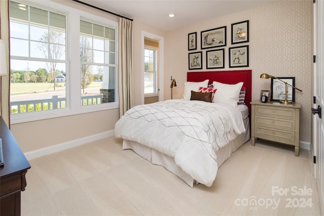 bedroom with multiple windows and light colored carpet