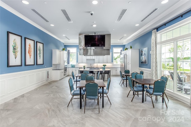 dining space with crown molding and plenty of natural light