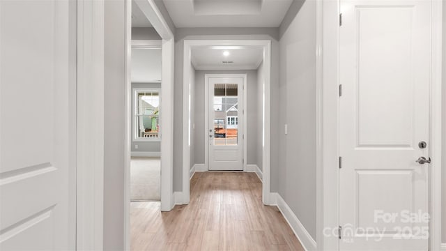 doorway to outside with baseboards and light wood-style floors