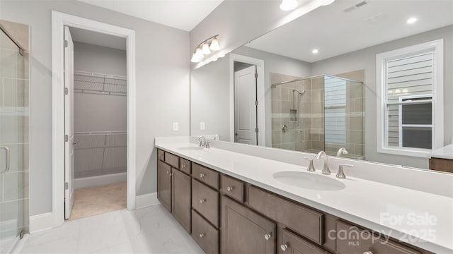 bathroom with marble finish floor, visible vents, a sink, and double vanity