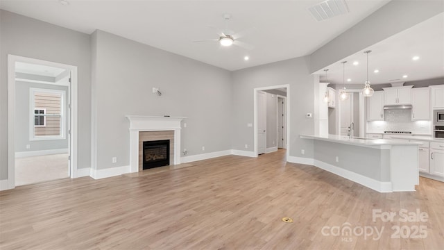 kitchen featuring light countertops, hanging light fixtures, visible vents, open floor plan, and white cabinetry