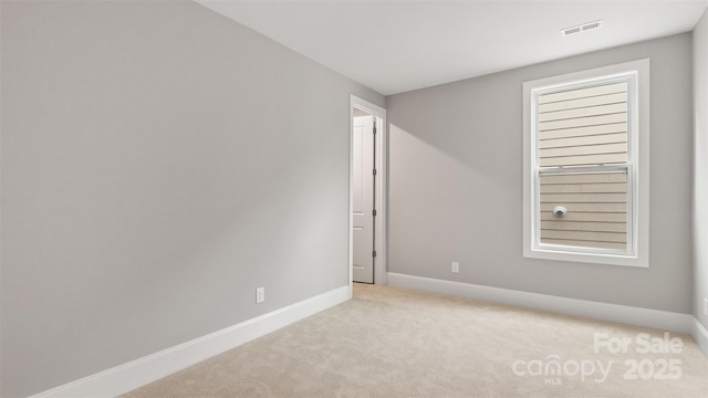 unfurnished room with baseboards, visible vents, and light colored carpet