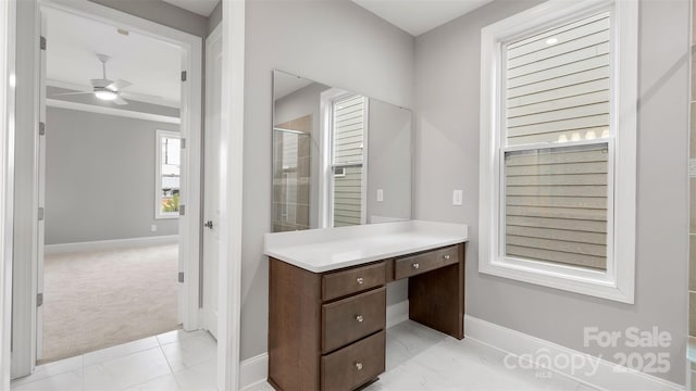 bathroom featuring a stall shower, baseboards, a ceiling fan, and vanity