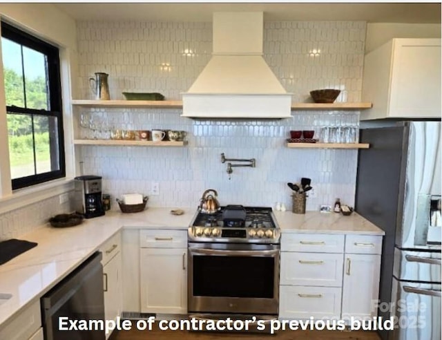 kitchen featuring custom exhaust hood, decorative backsplash, light stone countertops, white cabinetry, and stainless steel appliances