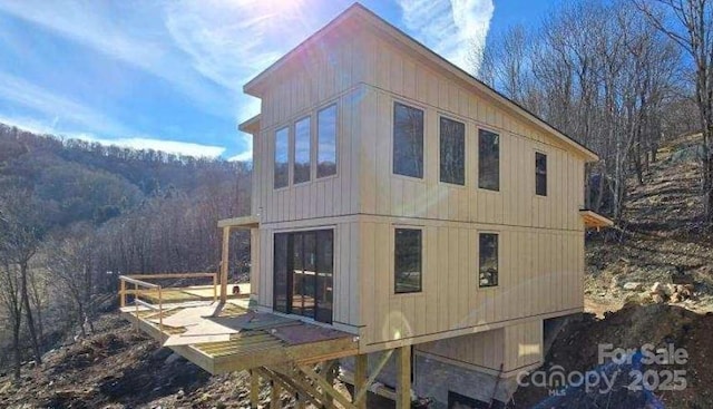 view of side of home featuring a wooded view